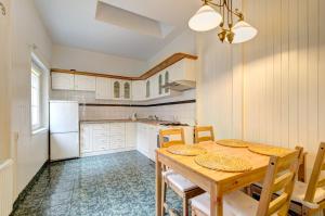 ソポトにあるDom & House - Apartment Fiszera Sopotのキッチン(テーブル、椅子、冷蔵庫付)