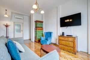a living room with a couch and a tv at Dom & House - Apartment Fiszera Sopot in Sopot