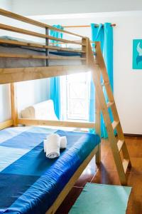 a bunk bed with a ladder and two towels on the bottom bunk at Family House in Baleal in Ferrel