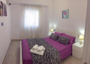 バレンシアにあるBelchiteのベッドルーム1室(紫色のシーツとシマウマの枕が備わるベッド1台付)