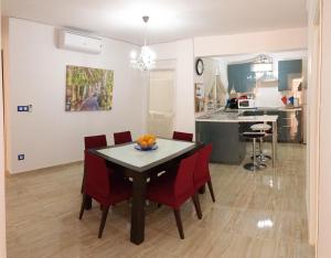 une salle à manger et une cuisine avec une table et des chaises rouges dans l'établissement Belchite, à Valence