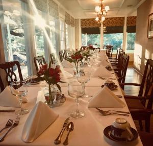 un comedor con una mesa larga con manteles blancos en Inn On The River, en Glen Rose