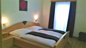 a bedroom with a bed with white pillows and a window at Appartement Pichler in Radstadt