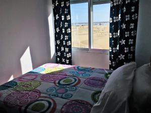 a bedroom with a bed with a view of the beach at Apartamentos Calypso in Punta Umbría