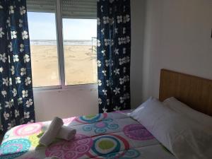 a bedroom with a bed with a view of the beach at Apartamentos Calypso in Punta Umbría
