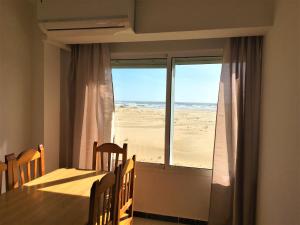 a dining room with a table and a view of the beach at Apartamentos Calypso in Punta Umbría