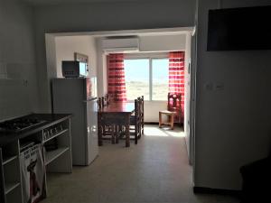 a kitchen and dining room with a table and a refrigerator at Apartamentos Calypso in Punta Umbría