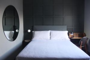 a bedroom with a white bed and a mirror at c-hotels Diplomat in Florence