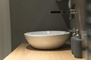 a bowl sink sitting on a wooden counter in a bathroom at San Lorenzo 42 in Rome