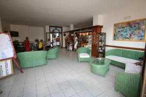 un restaurante con sillas verdes, una mesa y gente en Residence Club Barbara, en Ostuni