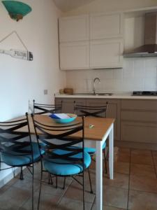 een keuken met een houten tafel en stoelen bij Villino Asfodeli in San Teodoro