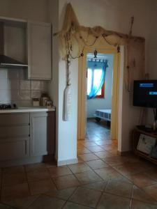 una cocina con una puerta que conduce a una sala de estar en Villino Asfodeli, en San Teodoro