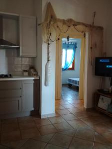 een keuken met een deur die naar een woonkamer leidt bij Villino Asfodeli in San Teodoro