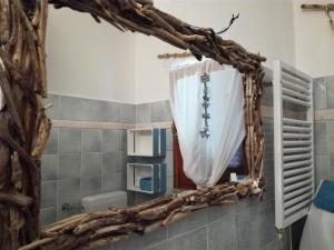 espejo en el baño con marco de rama de árbol en Villino Asfodeli, en San Teodoro