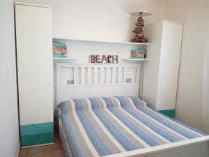 een slaapkamer met een bed met een gestreept matras bij Villino Asfodeli in San Teodoro