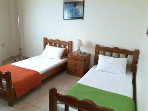 um quarto com 2 camas e uma mesa de cabeceira com um candeeiro em Old town apartment em Lerápetra