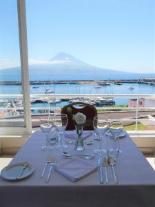 a table with wine glasses and napkins and a view of a harbor at Azoris Faial Garden – Resort Hotel in Horta