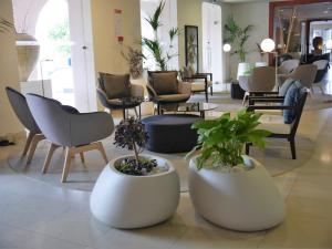 a lobby with chairs and potted plants on the floor at Azoris Faial Garden – Resort Hotel in Horta