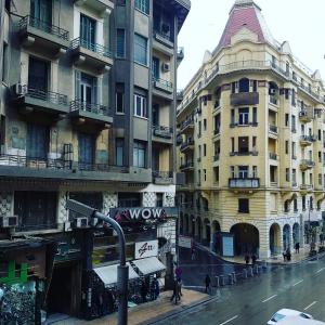 een straat met hoge gebouwen en mensen die op straat lopen bij Hostgram Hotel in Caïro