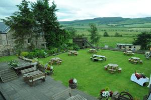 una vista aérea de un jardín con mesas y bancos en Three Wheat Heads, en Thropton