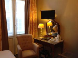 a bedroom with a desk with a chair and a mirror at Hotel Botaniek in Bruges