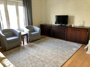 - un salon avec deux chaises et une télévision à écran plat dans l'établissement Apartamento Canto da Maia, à Ponta Delgada
