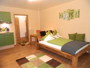 a bedroom with a bed with green pillows at Hotel Dietz in Bopfingen