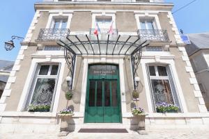 un edificio con una puerta verde delante de él en Best Western Plus Hôtel D'Angleterre en Bourges