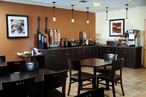 Un restaurante con una mesa y sillas y un mostrador. en Trend Mountain Hotel & Conference Centre, en Tumbler Ridge
