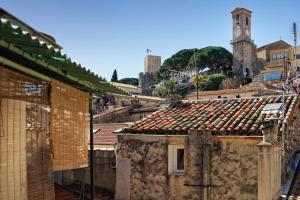 einen Blick auf die Dächer von Gebäuden mit einem Uhrturm in der Unterkunft Maison Bianchi - Forville in Cannes