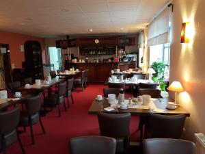 GadebuschにあるHotel Christinenhof garni - Bed & Breakfastのテーブルと椅子のあるレストラン、バー