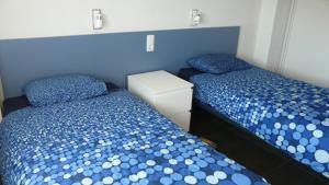 2 camas en un dormitorio con azul y blanco en Apartamento primera línea de playa, en Benicàssim