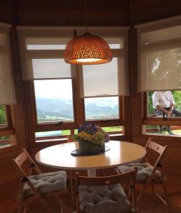 een eetkamer met een tafel, stoelen en ramen bij Landecoira in Sequeiro