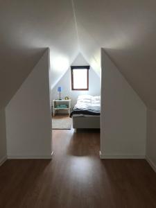 1 dormitorio en el ático con cama y ventana en Bed & Breakfast Höllviken en Höllviken