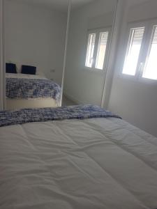 カディスにあるCaletaの白いベッドルーム(ベッド2台、窓2つ付)が備わります。