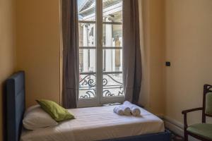 a bed with two towels on it in front of a window at Nunziata Apartment in Genova