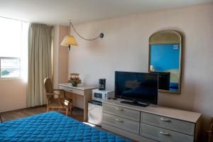 Habitación de hotel con cama, TV y espejo. en Hotel San Francisco, en Toluca