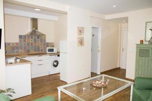a kitchen and living room with a glass table at Infanta Beatriz in Sanlúcar de Barrameda