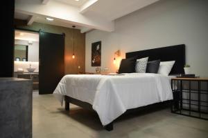 a bedroom with a large white bed and a bathroom at Casa Calila in San José Iturbide
