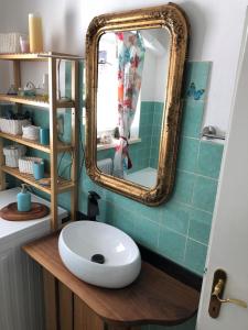 ein Badezimmer mit einem weißen Waschbecken und einem Spiegel in der Unterkunft Atelierwohnung Jirana in Saalfelden am Steinernen Meer