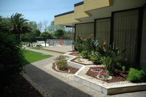 a garden with flowers and plants next to a building at Novotel Porto Gaia in Vila Nova de Gaia