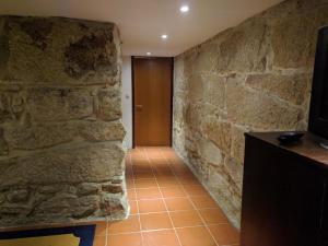 a hallway with a stone wall and a wooden door at Guesthouse Monsanto in Porto