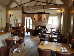 un restaurante con mesas y sillas y una chimenea en Monkey Brewhouse en Lymington