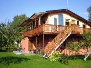 a large house with a deck and a yard at Guest House Vītoli in Kolka