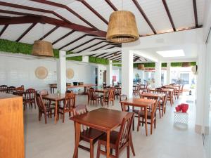 uma sala de jantar com mesas e cadeiras de madeira em Hotel Premium Recanto da Passagem em Cabo Frio