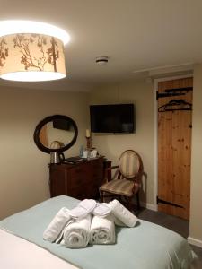 1 dormitorio con 1 cama y 3 toallas plegables en Monkey Brewhouse en Lymington