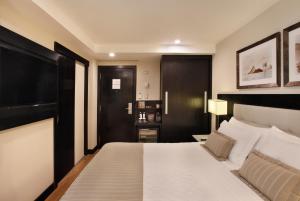 a bedroom with a large bed with a black headboard at Miramar By Windsor Copacabana in Rio de Janeiro