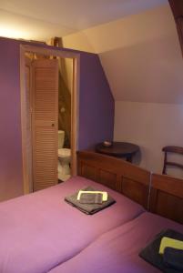 1 dormitorio con cama morada y espejo en B&B De Metstermolen en Sint-Truiden