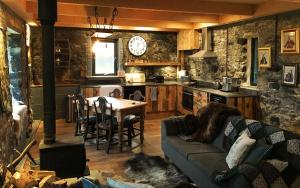 a living room with a couch and a table and a clock at Lusa Bothy in Lusa