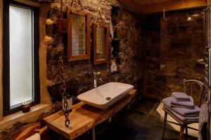 a stone bathroom with a sink and a window at Lusa Bothy in Lusa
